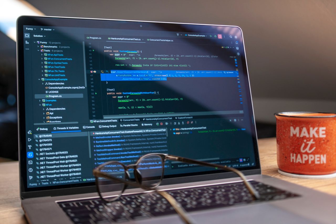 Crafting Captivating Headlines: Your awesome post title goes here A laptop displaying code editor with a motivational mug that reads 'Make It Happen' on a workspace.